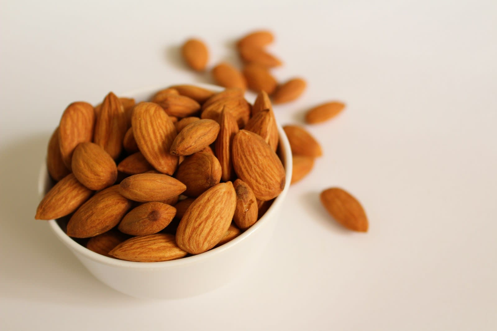 A white bowl of whole almonds, a food rich in magnesium