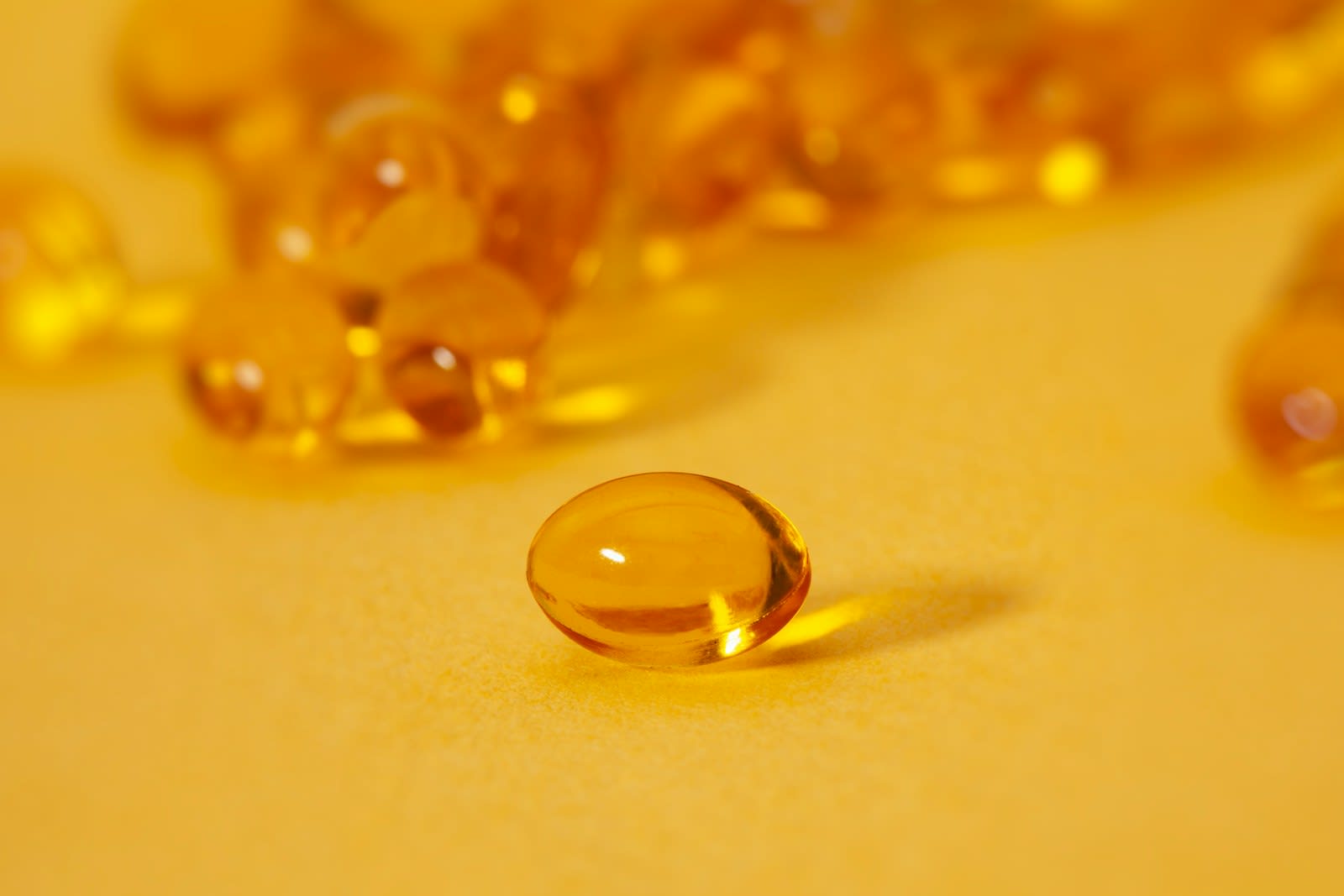 Close-up of amber vitamin D softgel capsules