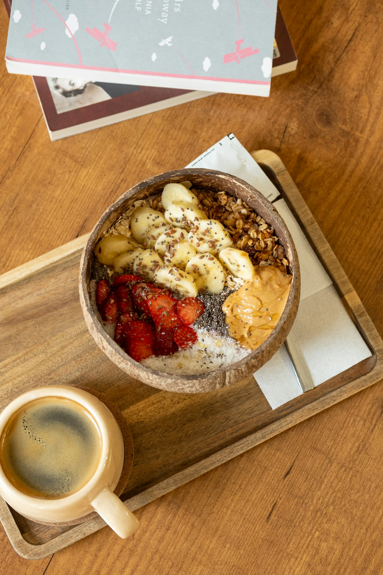 A breakfast bowl of oats with banana, strawberries and peanut butter