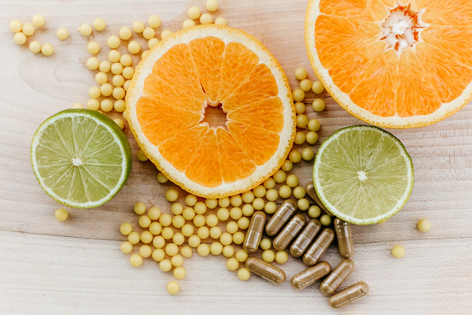 Supplement capsules beside sliced oranges and limes
